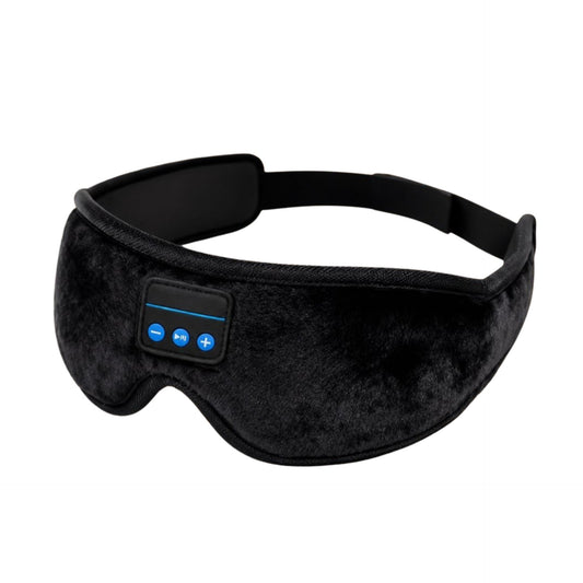Black velvet sleep mask with built-in Bluetooth controls for music, resting on cozy bedding