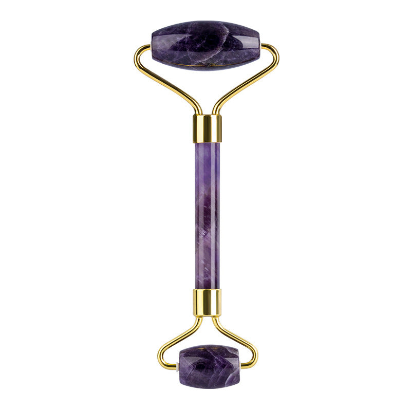 Purple jade roller with gold accents on a white background