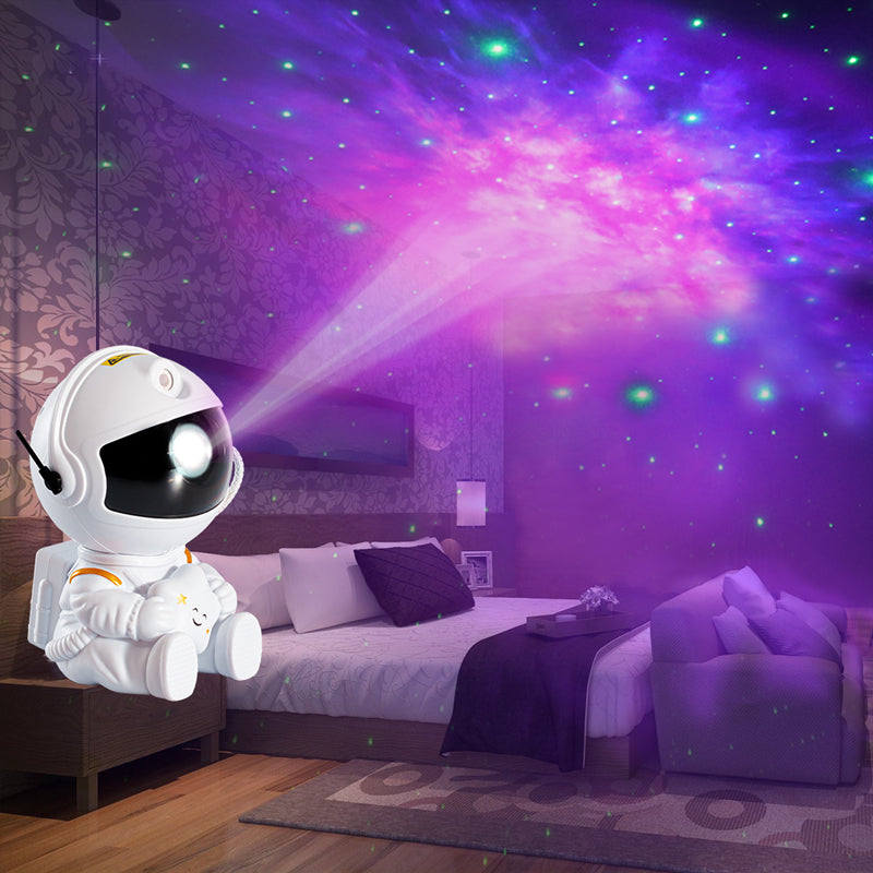 White astronaut galaxy star projector creating colorful nebula and star effects in a bedroom