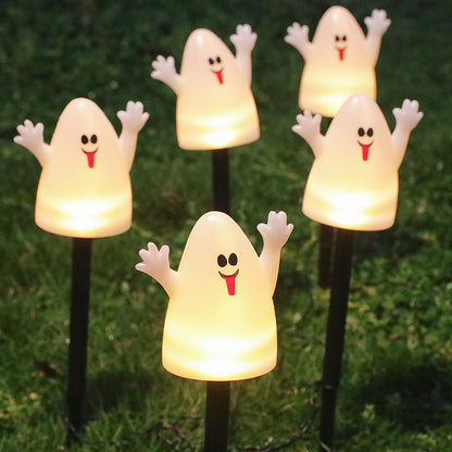 Glowing ghost-shaped solar lights arranged in a Halloween garden