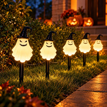 Ghost-shaped solar lights lining a decorated outdoor pathway