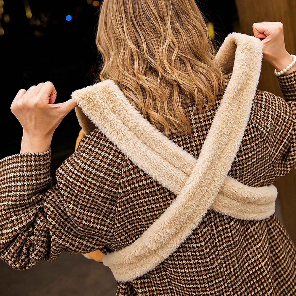 Rear view of a woman wearing a reindeer-themed pet carrier backpack