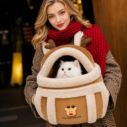 Reindeer-themed pet carrier worn by a woman with a white cat inside