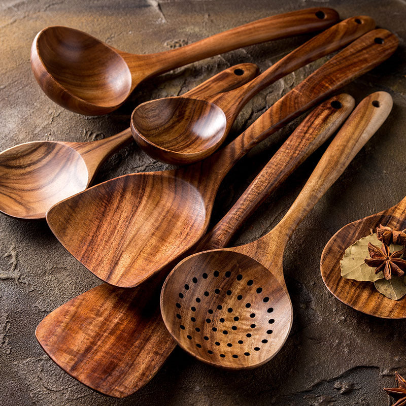 Teak wood kitchen utensil set with spoons, spatulas, and skimmer